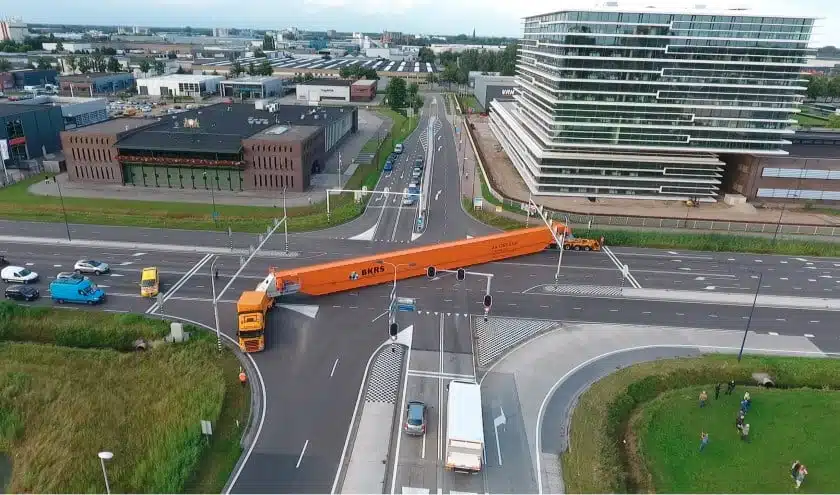 Kraan wordt vervoerd over een kruispunt
